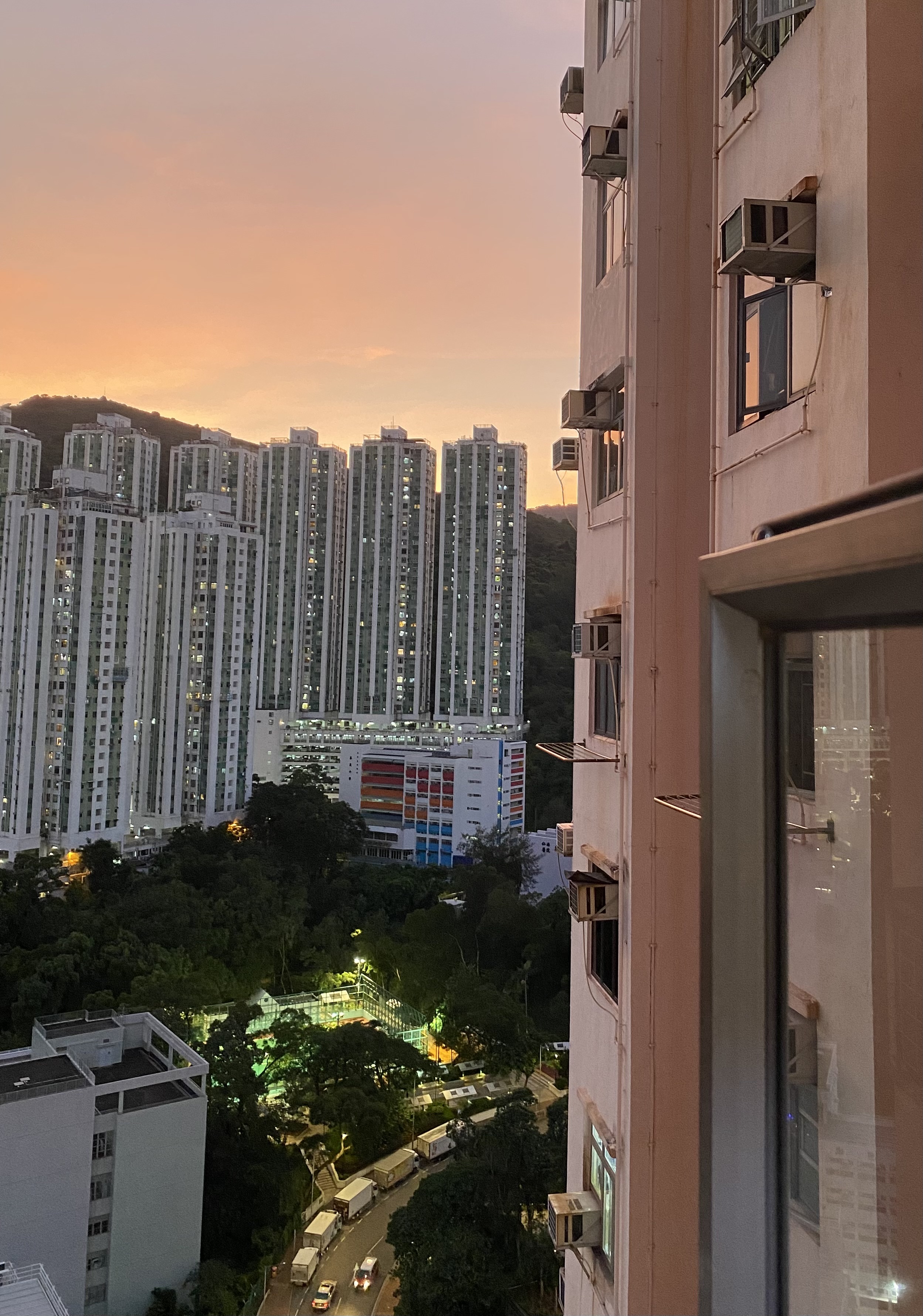 purple sky over an apartment complex on a hill in the distance, taken from a tall building